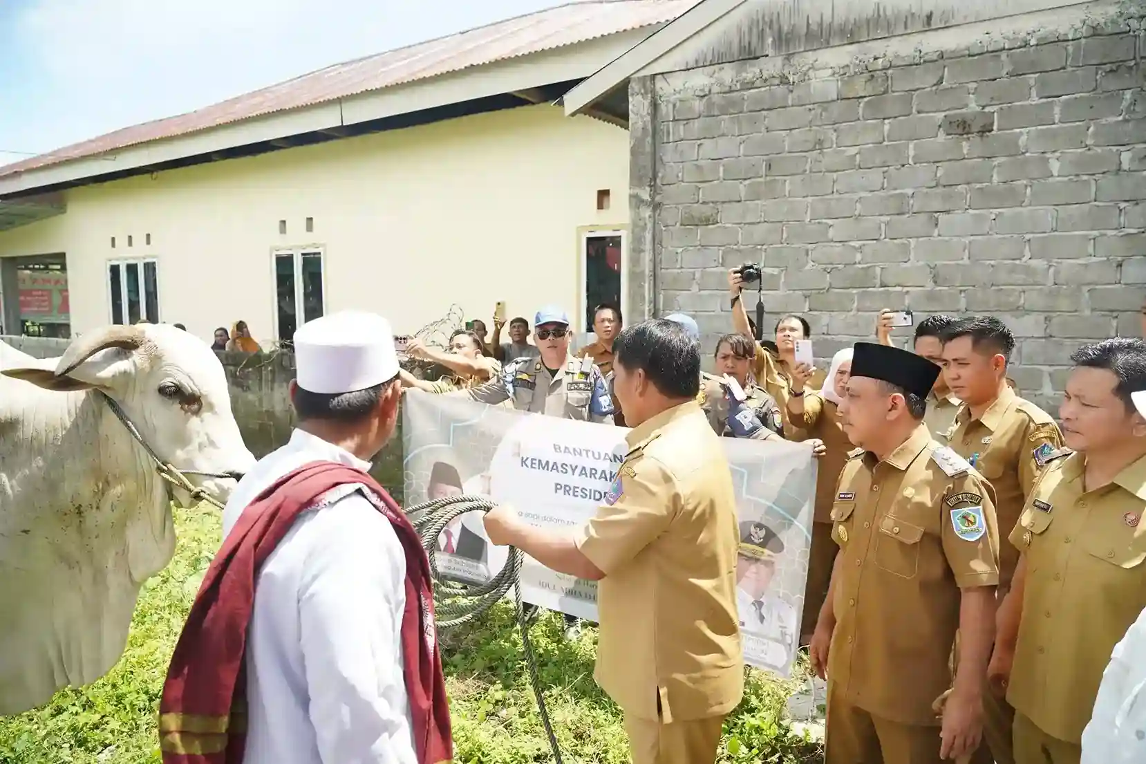 Penyerahan bantuan sosial kepada warga desa oleh pejabat pemerintah dan tokoh masyarakat.